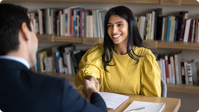 A woman in yellow shaking hands